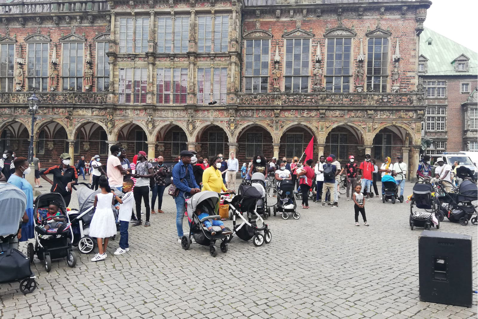 Protestors gathered and demonstrating in a busy town square.